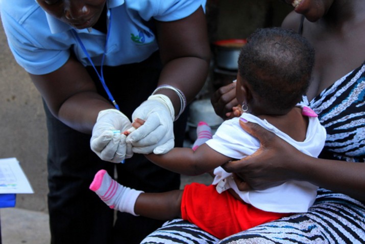 [A community health worker takes blood to check for malaria.] {Photo credit: Zina Jarrah/MSH, Tanzania.}