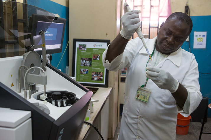 [Un empleado del hospital de Minna analiza una muestra de sangre para detectar el VIH.] {Crédito de la foto: Gwenn Dubourthoumieu - Estado de Níger, Nigeria}