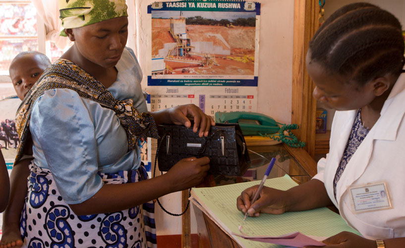 [Uma mulher e uma criança visitam um dispensador credenciado na Tanzânia.] {Crédito da foto: equipe da MSH}