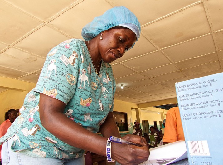 [ A health worker fills in a child’s immunization booklet during an immunization clinic at Phebe Hospital in central Bong County, Liberia. The Ebola epidemic disrupted routine immunizations. The USAID Collaborative Support for Health program, led by MSH, is supporting Liberia’s Ministry of Health to strengthen the country’s health system, including making it more resilient to deal with outbreaks like Ebola.] {Photo credit: Cindy Shiner/MSH}
