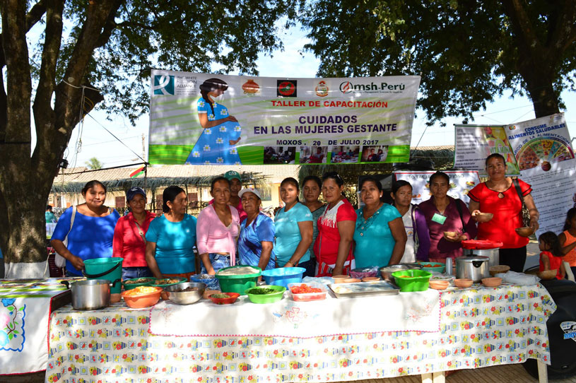 [Women leaders at a fair in Bolivia share healthy eating tips to pregnant and breastfeeding women.] {Photo credit: MSH-Perú staff}