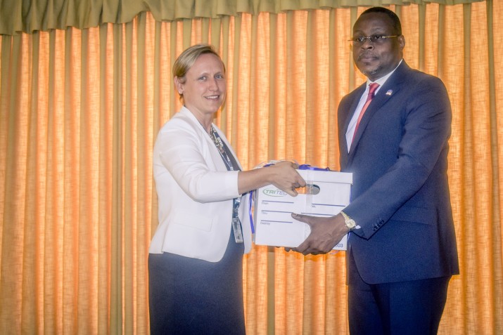 [Alyssa Leggoe of USAID/Haiti hands over LMG/Haiti project deliverables to Dr. Adrien Lauré, representing Haiti's health ministry.] {Photo credit: Patricia Forestal}