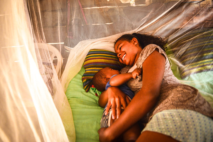 [Sleeping under an insecticide-treated mosquito net protects all community members from malaria.]