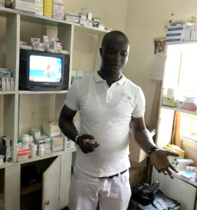 [Pharmacist Tamba M.D. Saquee explains how Makeni Government Hospital’s DTC supported the establishment of a cost recovery pharmacy at the hospital.] {Photo Credit: Gabriel Daniel/MSH}