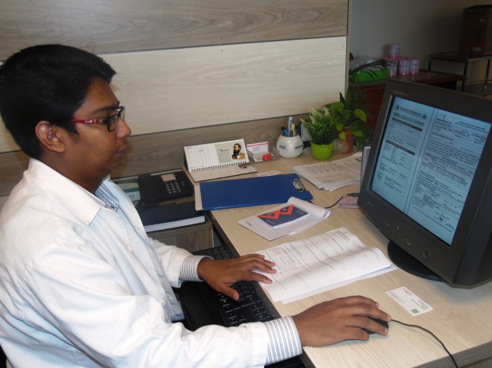 [Jahidul Hasan works on the adverse drug event report.]{Photo Credit: Liza Talukder}