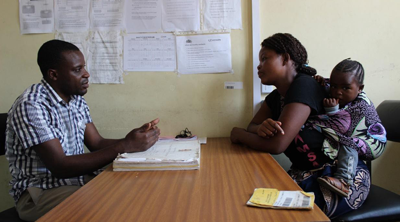 [Gift Chitukula, an HIV diagnostic assistant (HDA) for Makhetha Health Center, talks with a client about the importance of partner and family testing.] {Photo Credit: Henry Nyaka/MSH.}