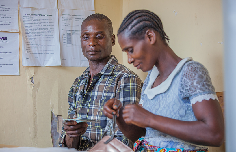 {Violet et Godfrey Justin rencontrent un conseiller VIH lors d'une visite au centre de santé de Bvumbwe au Malawi. Crédit photo : Moving Minds, Malawi.}