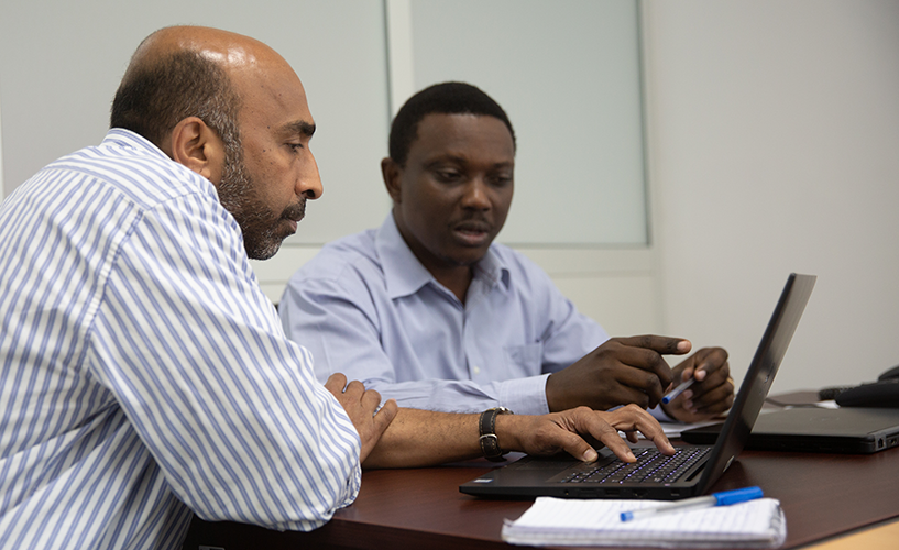 [Pfizer GHF, Jay Shetty, (à esquerda) com o Conselheiro Técnico Principal, Paul Bwathondi, (à direita) no escritório da MSH em Dar es Salaam, Tanzânia.] {Crédito da foto: Jonx Pillemer / Pfizer}