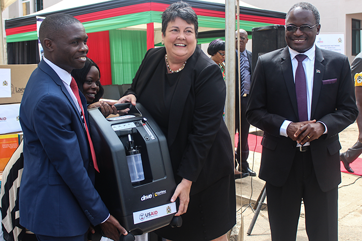 [Left to right: Dan Namarika, Principal Secretary of Health, Virginia Palmer, US Ambassador to Malawi, and Dr Charles Mwansambo, Chief of Health Services in the Ministry of Health and Population hold an oxygen concentrator, one of many pieces of medical equipment that have now been transferred to the MOH.]