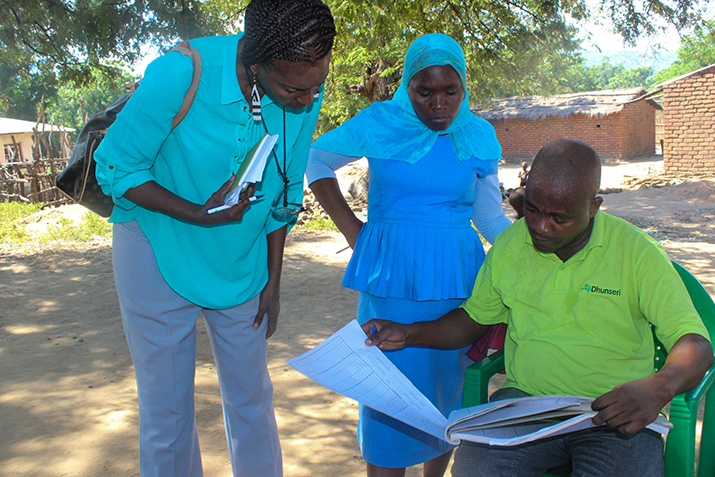 [PMI Resident Advisor, Xiomara Brown, reviews the number of malaria cases recorded for the month. Photo credit: Rejoice Phiri/MSH]