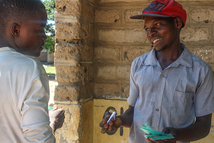 [Health worker provides a young man with instructions for malaria treatment. Photo credit: Rejoice Phiri/MSH] 