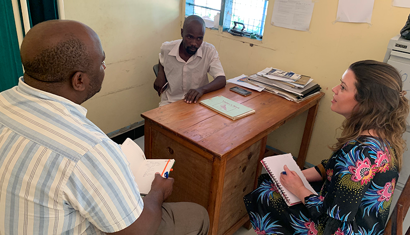 [La becaria de salud global de Pfizer, Megan Montgomery, y Peter Mmbago, asesor de recursos humanos para la salud de TSSP, entrevistan a un proveedor de atención médica en Bagamoyo, Tanzania.]