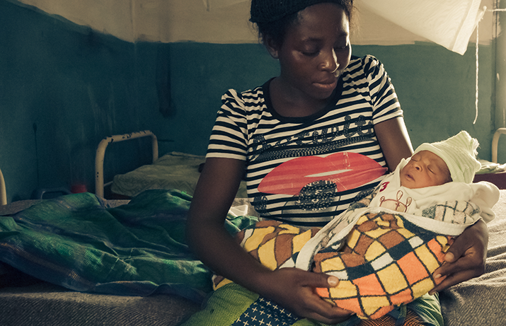 [A mother holds her newborn at a hospital in Mwene-Ditu, Democratic Republic of the Congo] {Photo Credit: Warren Zelman}