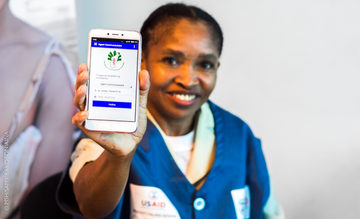 [Une volontaire de santé communautaire à Madagascar montre le téléphone portable qu'elle utilise pour enregistrer les données de santé des patients.] {Crédit photo : Samy Rakotoniaina/MSH}