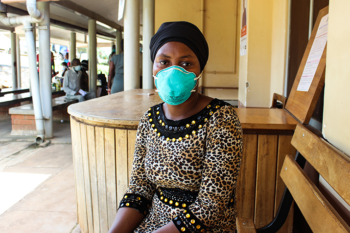 {Asther Zabibu, an MDR-TB survivor sits outside the TB treatment centre at Mulago National Referral Hospital in Uganda. where she now provides psycho-social support to other patients and counsels them on adherence. Photo Credit: Sarah Lagot}