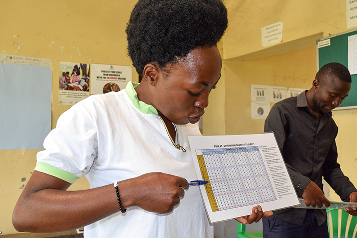 [Barbara Kabagenyi, Nurse at Karugutu Health Center trains parish coordinators in Bweramule on how to use the magic calculator. Photo credit: MSH]