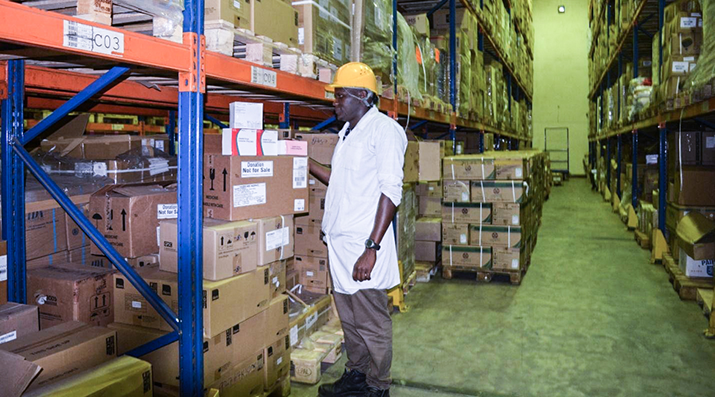 [Nathan Kisakye, senior warehouse assistant at the Joint Medical Store, picks and packs commodities for a client. Photo credit: MSH staff]