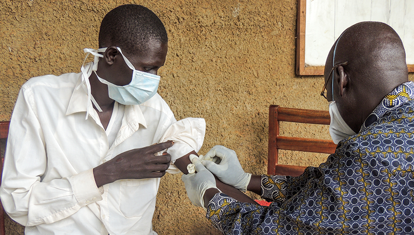 [Un trabajador de la salud toma una muestra de sangre de un paciente con TB-XDR en el Hospital Kitgum en el norte de Uganda.] {Crédito de la foto: Diana Tumuhairwe / MSH}