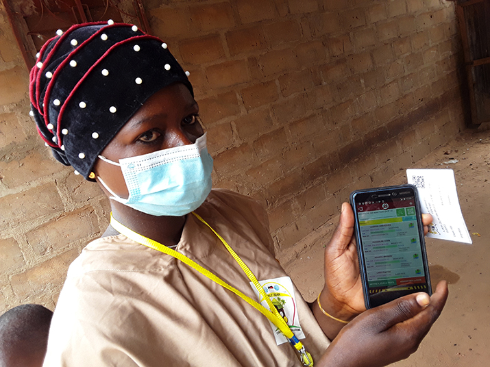[Um trabalhador de saúde mostrando o aplicativo usado durante o SMC na aldeia de Guéné. Crédito da foto Jocelyn Akakpo]