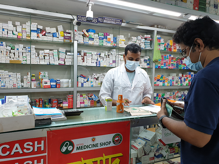 [A client picks up a prescription at a private-sector drug shop in Dhaka, Bangladesh.] {Photo credit: Raian Amzad/MSH}