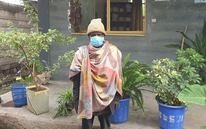 [Temesgen Zewdu visita el centro de salud de Keta para recoger sus medicamentos contra la tuberculosis y cuidar de la planta que le ha sido dedicada.] {Crédito de la foto: Hatoluf Melkamu}