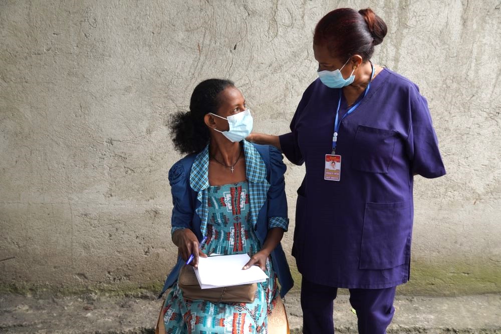 A woman receiving TB medicines from her nurse.