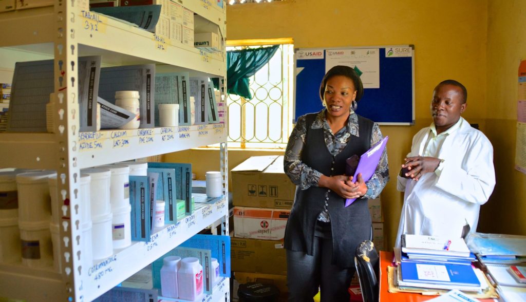 Um supervisor de gestão de medicamentos visita funcionários de farmácia em Uganda