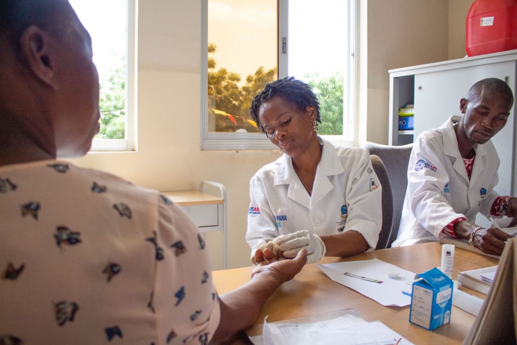 Técnico sanitario realizando una prueba en un centro sanitario de Luanda foto de Alanna Savage