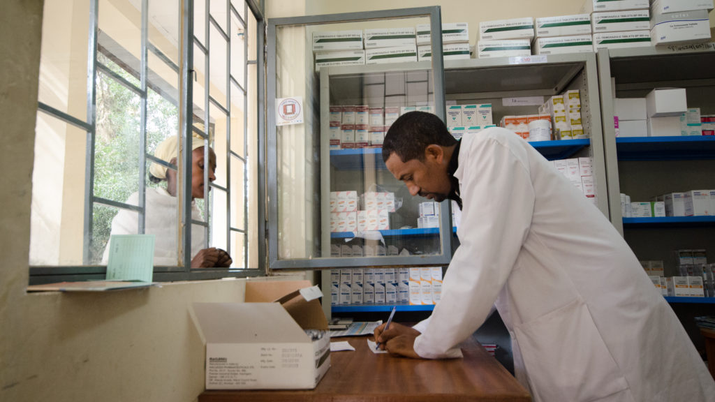 Farmacêutico masculino na Etiópia preenche uma prescrição