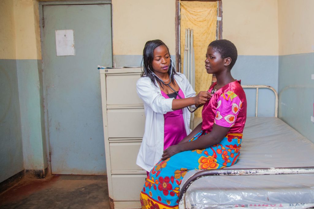 A medical assistant checks on a patient