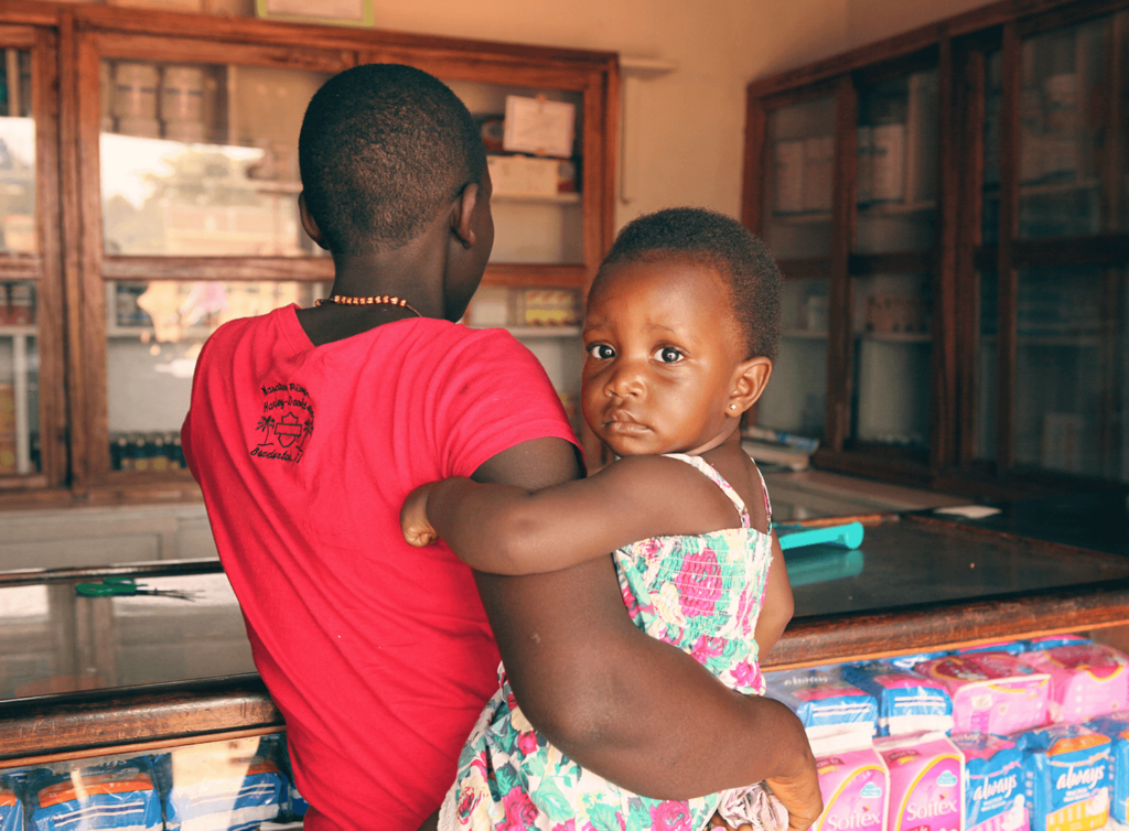 mãe e filho em Uganda na loja de remédios