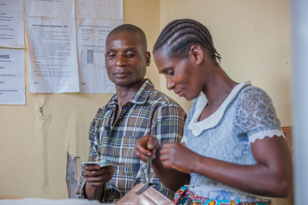 Violet y Godfrey Justin se reúnen con un consejero de VIH durante una visita al Centro de Salud Bvumbwe en Malawi. Foto de Moving Minds.