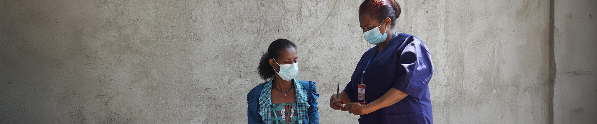 A community health worker providing a TB patient with a new prescription