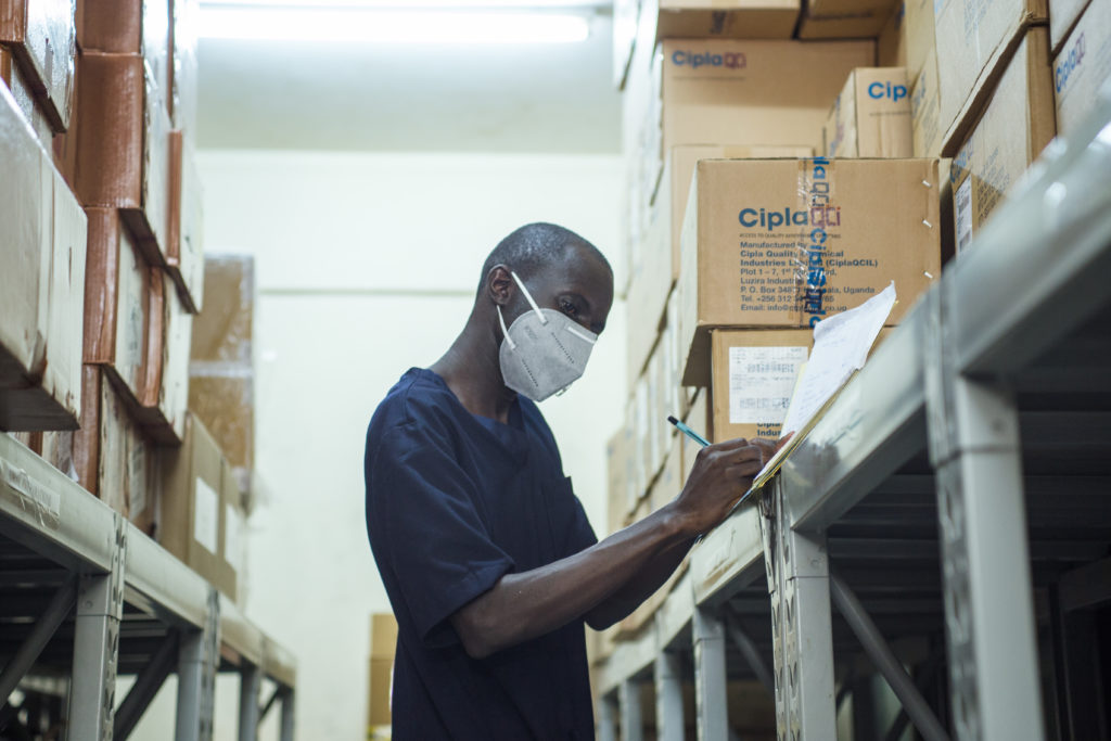Homem em Uganda analisa inventário de medicamentos