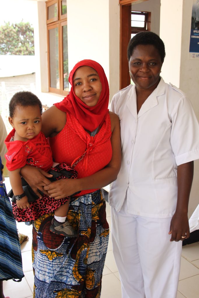 Trabajador sanitario con madre e hijo, foto de Brooke Huskey