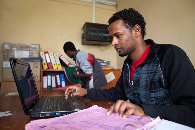 An inventory specialist working on a laptop.