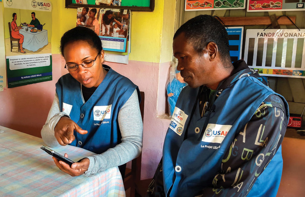 Freiwilliger im Gesundheitsbereich der Gemeinde nutzt die mobile Gesundheits-App