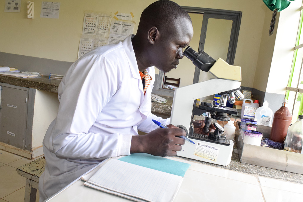 Okello Emmanuel, a cargo del laboratorio en el Centro de Salud Princess Diana en Uganda, realiza una prueba de microscopía. Crédito de la foto MSH-XL