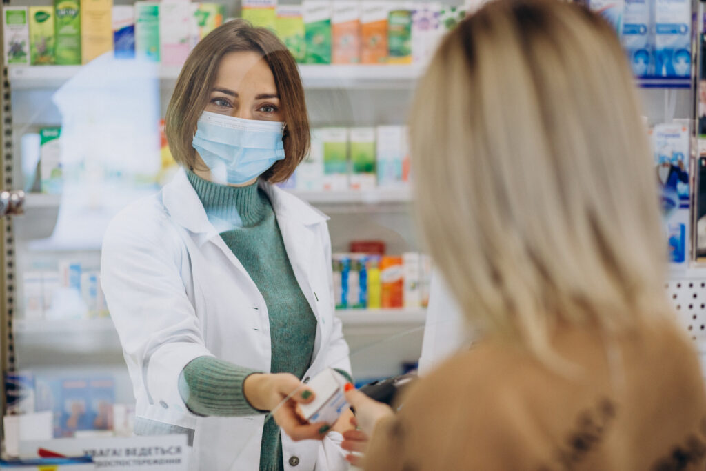 Pharmacist serving customer at drug store. Stock image from the Ukraine team.