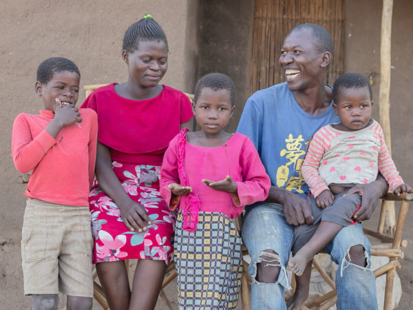 Una familia de cinco integrantes frente a su casa en Malawi.