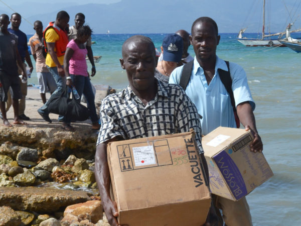 Men carrying boxes full of aid in Haiti