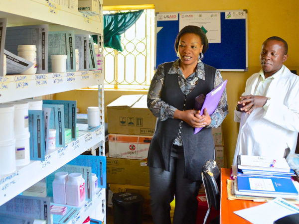Um supervisor de gerenciamento de medicamentos visita a equipe de uma farmácia em Uganda.