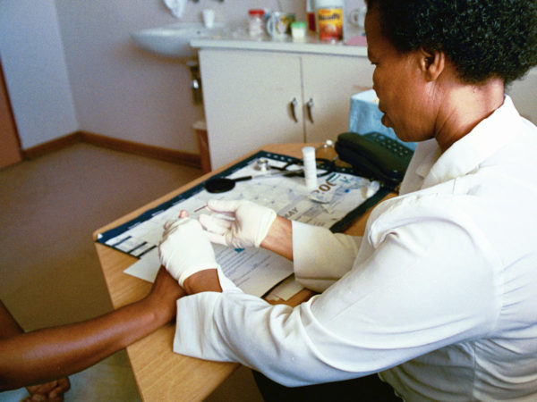 A health worker in South Africa performs an HIV test on a patient.