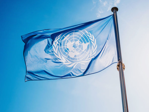 Flagge der Vereinten Nationen gegen den blauen Himmel