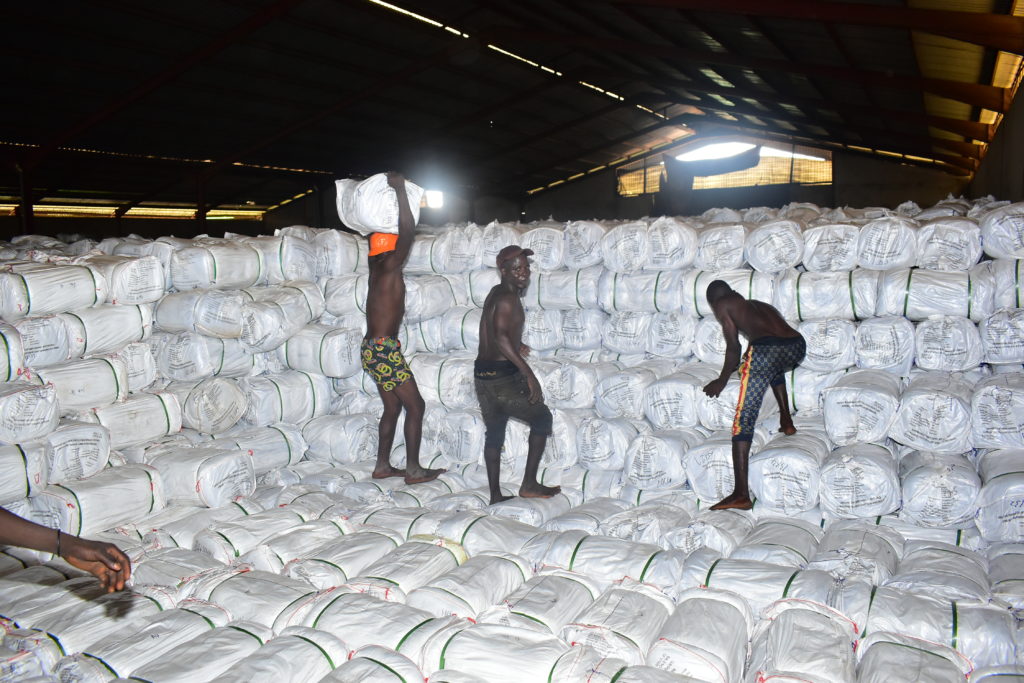 Workers pile bundles of insecticide-treated bed nets at a central warehouse in preparation for mass distribution in Nigeria's Delta state.