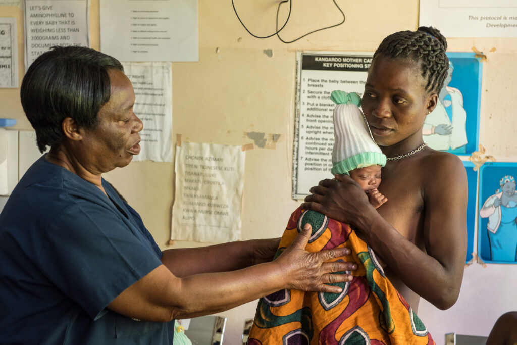 Un agent de santé enseigne à une mère qui tient son bébé les bases des soins maternels kangourou, Bwaila Hospital, Lilongwe, Malawi. Crédit photo : Rudi Thetard/MSH