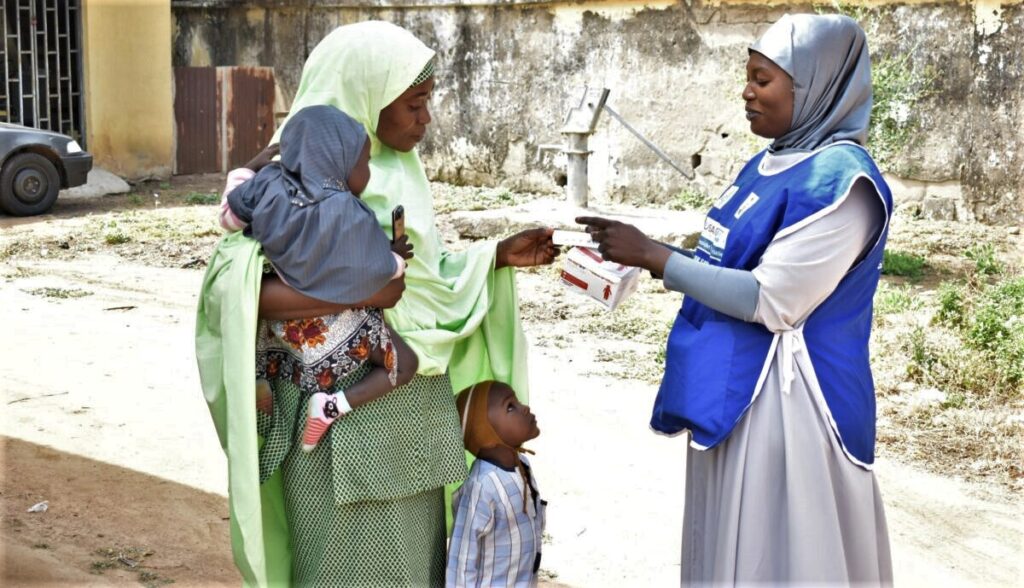 Una madre recibe medicamentos contra la malaria estacional para sus hijos de un trabajador de la salud. Crédito de la foto: Proyecto PMI-S, Nigeria, malaria