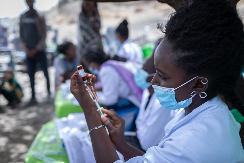 La trabajadora de extensión de salud Mariam Kegne prepara una vacuna en el sitio de desplazados internos de Mindikru en Etiopía.
