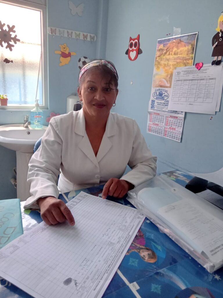 Guatemala - Aurora, trabajadora de salud de la ANC en San Marcos, sentada en su escritorio revisando registros en un centro de salud.