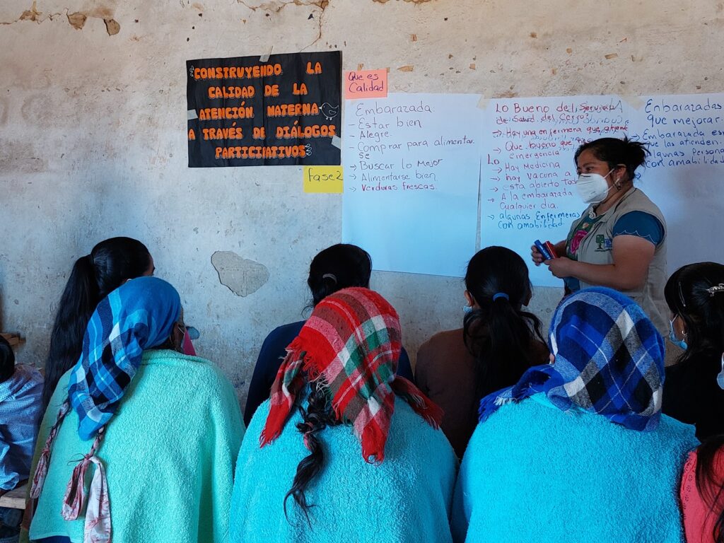 Um profissional de saúde modera uma sessão de Diálogos Comunitários para mulheres grávidas e outros membros da comunidade na Guatemala como parte do Projeto Mães e Bebês Saudáveis ​​na Guatemala
